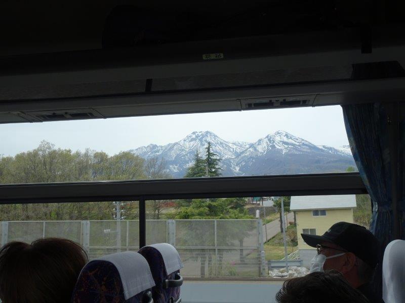 長野県と新潟県の間を曲がりくねる高速道路、左右にゃ山だらけでしてん。高い山じゃ、雪防止を被ってんやってぇ!